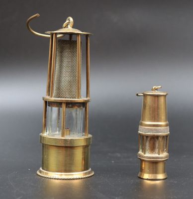 pair of brass and glass lighthouse lamps on a black surface