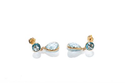 gros plan d'une paire de boucles d'oreilles sur une surface blanche