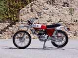 a red and white motorcycle parked in front of a stone wall