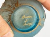 a person holding a blue vase with writing on it