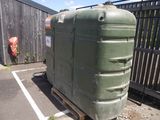 a large green tank sitting on a pallet in a parking lot