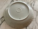 a white plate with a ring on it sitting on a marble table