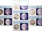 a group of six different types of silver coins in a display case