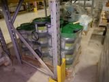 many barrels of green and white paint on a shelf