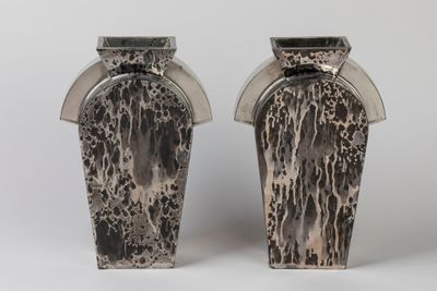 deux vases posés côte à côte sur une surface blanche