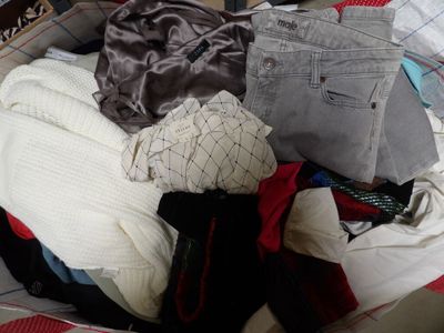une valise remplie de vêtements posée sur un lit
