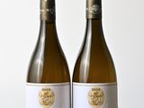 deux bouteilles de vin posées l'une à côté de l'autre sur une table en bois