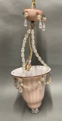 une lampe suspendue à un lustre composé de perles de verre