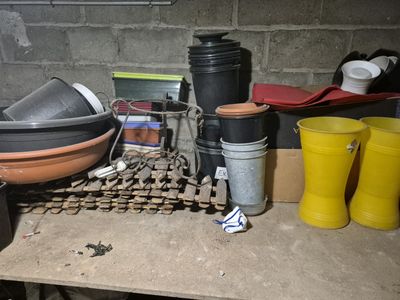 de nombreuses casseroles et poêles posées sur une table dans une pièce
