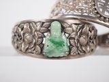 a silver ring with a green stone in it