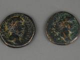 deux pièces de monnaie romaines anciennes, dont l'une représente un visage et l'autre une tête