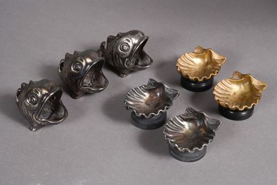 six pieces of silver and gold colored metal on a gray surface