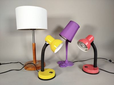 Plusieurs lampes de différentes couleurs sont alignées sur une table