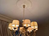 a chandelier that has five lamps on it in a room