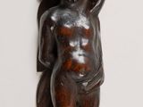 an image of a wooden sculpture of a boy holding a bird