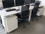 trois ordinateurs posés sur les bureaux de ce bureau