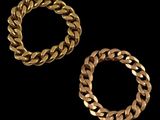 two gold bracelets on a black background