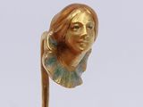a gold statue of a woman on top of a stick