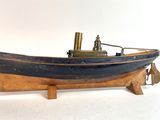 une petite maquette de bateau posée sur un socle en bois