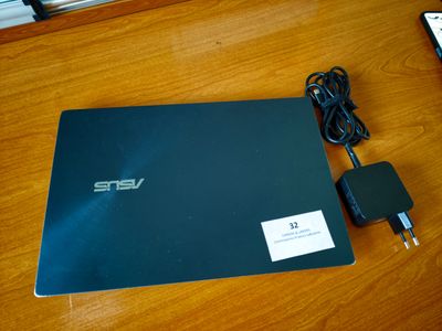 un ordinateur portable posé sur une table avec un chargeur