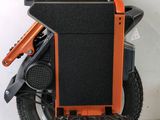 an orange and black electric scooter sitting on top of a white wall