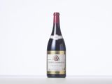 a bottle of red wine sitting on top of a white table