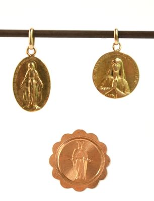 trois médailles d'or suspendues à une ficelle sur fond blanc