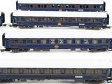 several blue train cars are lined up in a row on a white surface