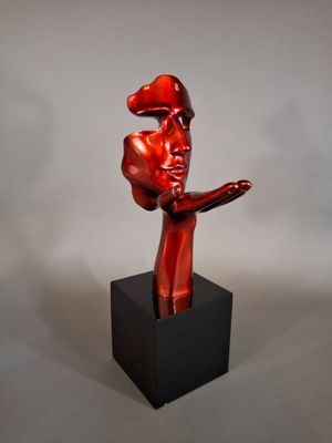 statue of a man with a hat on his head and hands in the air