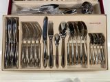 a lot of silverware in a box on the table