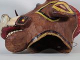 a wooden sculpture of a rhino head with a yellow and red face