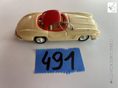 une petite voiture miniature avec un toit rouge et un numéro dessus