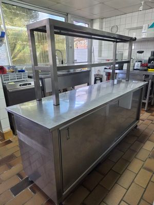 plan de travail en acier inoxydable dans une cuisine professionnelle avec un sol carrelé
