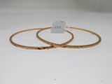 deux bracelets rigides en or sur fond blanc, avec une étiquette de prix
