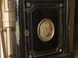 a black and gold cabinet with a clock on top of it