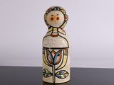 a picture of a wooden doll on a black surface