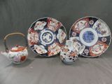 trois assiettes et une théière posées sur une table
