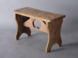a small wooden bench with a hole in it
