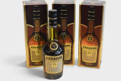 three bottles of whisky sitting next to each other on a white surface