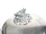 a silver plate with a dog on top of it