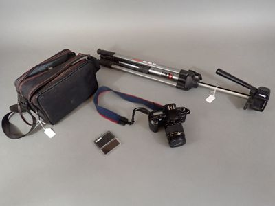 a bag, camera, tripod, and other items laid out on a table