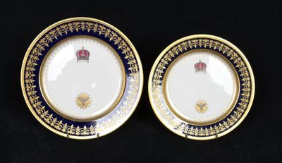 two plates with gold and blue designs on them on a black surface