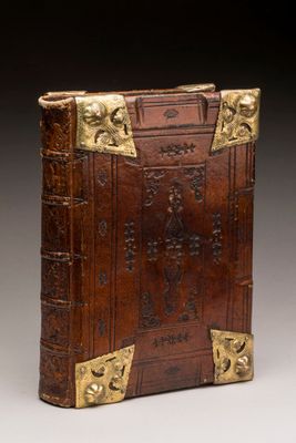 an old leather book with gold trimmings and a cross on the front