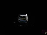 a black room with a chair and a window in it