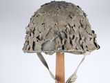 un vieux casque fixé sur un bâton en bois, sur fond blanc