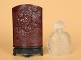 un petit vase et une petite bouteille en verre posés sur une table