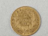 a close up of a gold coin on a white surface
