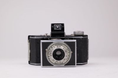 une photo en noir et blanc d'un appareil photo sur une surface blanche