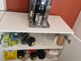 a coffee maker sitting on top of a shelf in the corner of a kitchen