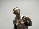 bronze statue of a woman with a bird on her shoulder